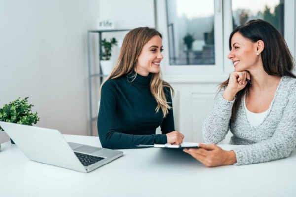 Two smiling female colleagues in the office. Working together.